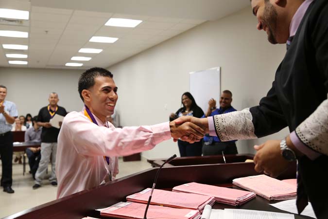 El Juez Administrador de la Región de Caguas, Hon. Ricardo Marrero Guerrero, entregó medallas y certificados a todos los participantes que terminaron el proceso. En la foto, Yamil se despide del Juez Administrador mientras los presentes aplauden su logro. El Juez Administrador de la Región de Caguas, Hon. Ricardo Marrero Guerrero, entregó medallas y certificados a todos los participantes que terminaron el proceso. En la foto, Yamil se despide del Juez Administrador mientras los presentes aplauden su logro.